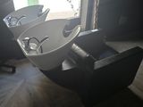 two sinks in a room with a window and a chair
