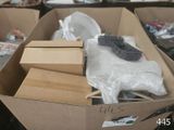 une boîte en carton remplie d'objets hétéroclites sur le sol
