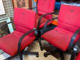 two red chairs sitting next to each other in a room