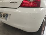 a white car parked in a garage with a license plate on it