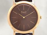 a close up of a watch with a brown dial