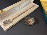 a silver spoon in a box with a spoon in it