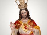 statue of jesus wearing a crown and holding his hands up