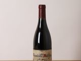 une bouteille de vin rouge posée sur une table en bois