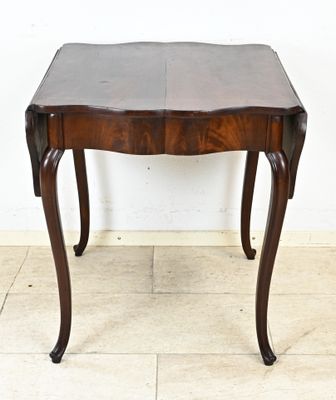 une petite table en bois avec un plateau en cuir, posée sur un sol carrelé