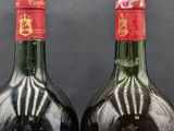 two bottles of wine that are sitting next to each other