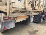 a dirty dump truck parked on the side of the road
