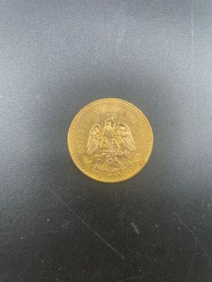 a close up of a gold coin on a black surface