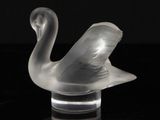 a glass sculpture of a swan on a black surface