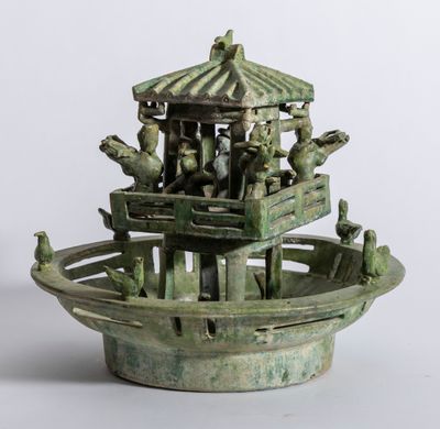 une statue verte représentant un bateau avec des personnes à bord