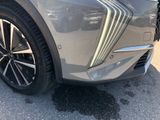 the front end of a silver car with black rims and chrome trims