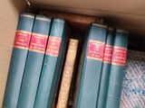many books in a cardboard box on the floor