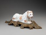 une statue représentant un lion allongé sur une branche d'arbre