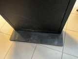 un four noir posé sur un sol carrelé dans une cuisine