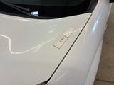 a close up of a white car with a sticker on it