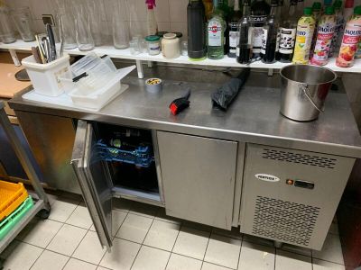 un comptoir en acier inoxydable sur lequel sont posées plusieurs bouteilles