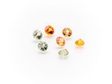 a group of five different colored gems on a white surface