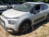 une Citroën argentée garée dans l'herbe à côté d'autres voitures