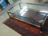 une table basse en verre posée sur un tapis dans une pièce