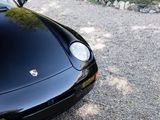 a black sports car parked on a gravel road
