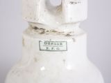 a close up of a white vase with a green label on it