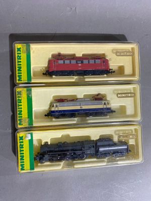 trois petits trains qui se trouvent dans une boîte posée sur la table