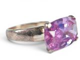purple stone ring on a white surface with a silver band