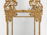 un miroir doré richement décoré, orné d'un motif représentant un oiseau et une fleur
