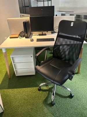 a desk with a chair and a computer on it