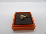 an orange box with a ring inside of it on a white surface