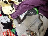 a pile of clothes that is sitting on a bed