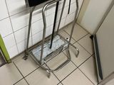 a metal stool in the corner of a bathroom