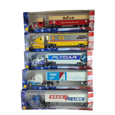 six camions miniatures dans une vitrine sur fond blanc