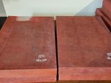 two red books sitting on top of a wooden table