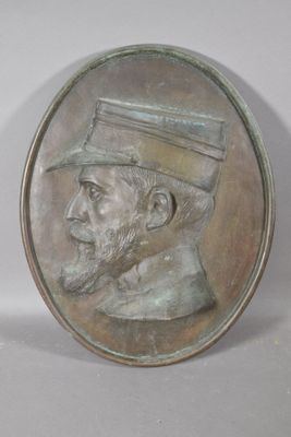 a silver medal with a man wearing a hat on it