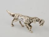 a silver figurine of a dog with a tag on it