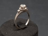 an image of a diamond ring sitting on top of a black rock