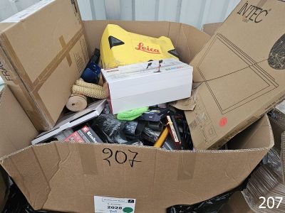 a cardboard box filled with assorted items on the ground