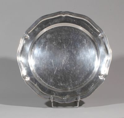 a silver plate on a stand on a white surface