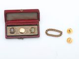 une petite boîte rouge contenant une montre en or et une chaîne