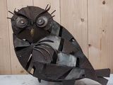 a metal sculpture of an owl sitting on top of a table