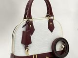 a white and maroon handbag with a leather strap and a belt