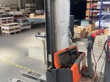 un chariot élévateur dans un entrepôt, avec des palettes en arrière-plan