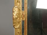 a gold frame with a mirror on it on a table