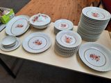 une table sur laquelle se trouvent beaucoup d'assiettes et de bols