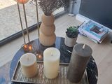 une table avec des bougies et un plateau sur lequel sont disposées des fleurs
