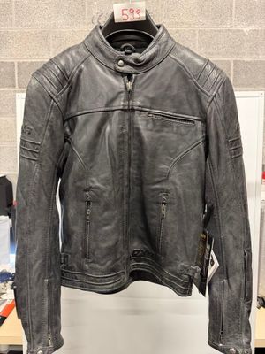une veste en cuir noir suspendue à un cintre devant un mur
