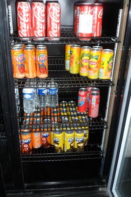 de nombreuses canettes de soda dans un réfrigérateur