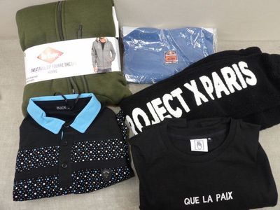 un tas de vêtements et un t-shirt posés sur un canapé
