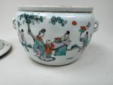 a bowl with a lid and a plate with a picture of people on it